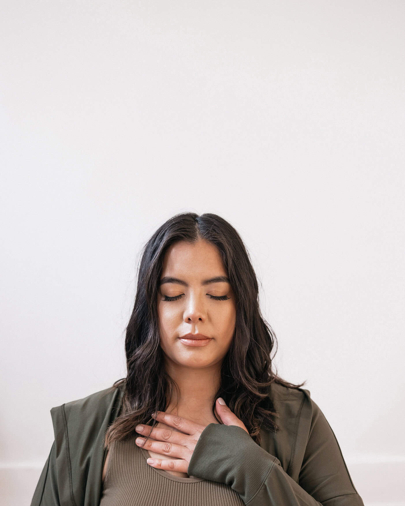 woman eyes closed, hand on chest