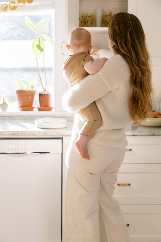 woman holding toddler in kitchen